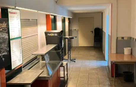 In der Kantine im Gewerbegebiet Altlandsberg führen Fliesenboden, Verkaufstheke und Sitzbereich zu den Nebenräumen und dem Ausschank.