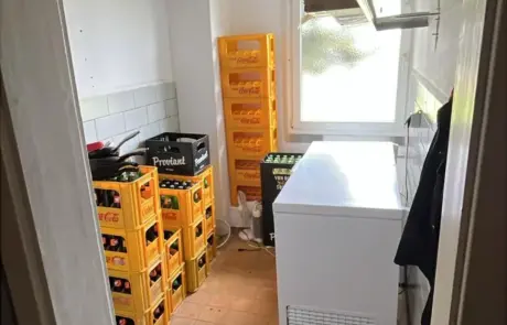 In der Kantine im Gewerbegebiet Altlandsberg stehen Getränkekisten, ein Tiefkühler und eine kleine Küche mit Arbeitsfläche bereit.