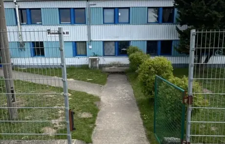 Über den gepflasterten Weg und die Treppe führt der Zugang zur Kantine im Gewerbegebiet Altlandsberg, vor einem zweigeschossigen Gebäude.